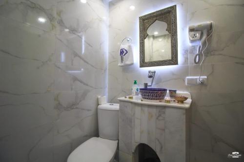 a bathroom with a toilet and a sink and a mirror at Casa Sanae in Chefchaouene