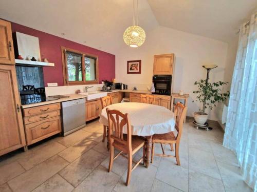une cuisine avec une table et des chaises dans une pièce dans l'établissement Maison familiale Drôme - Ardèche, à Châteauneuf-du-Rhône