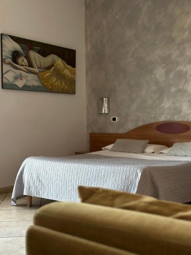 a bedroom with a bed and a painting on the wall at Hotel Il Giardino degli Aranci in Nola