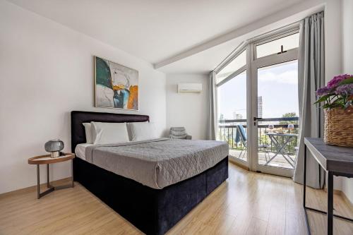 a bedroom with a bed and a large window at Marathon Beach Apartment - Sea View, Shared Pool in Limassol