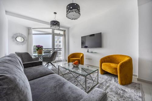 a living room with a couch and two chairs and a table at Marathon Beach Apartment - Sea View, Shared Pool in Limassol