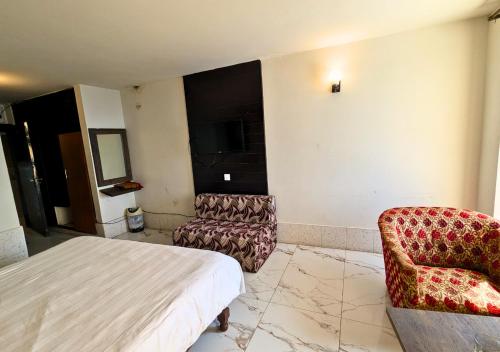 a hotel room with a bed and a chair at Grand Heights Hotel in Murree