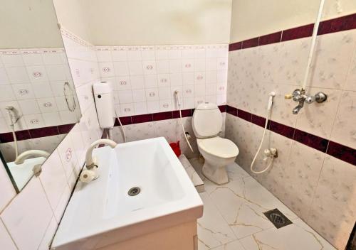a bathroom with a sink and a toilet at Grand Heights Hotel in Murree