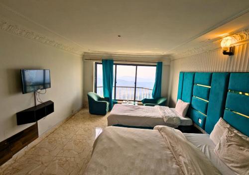 a hotel room with two beds and a television at Grand Heights Hotel in Murree