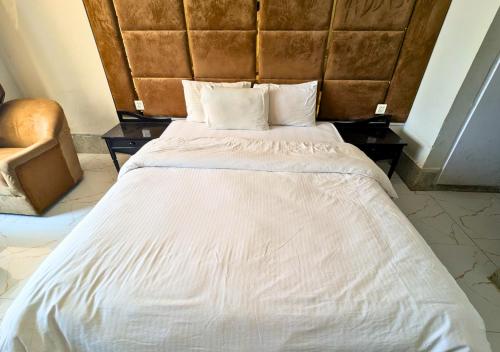 a large white bed with a large headboard in a room at Grand Heights Hotel in Murree
