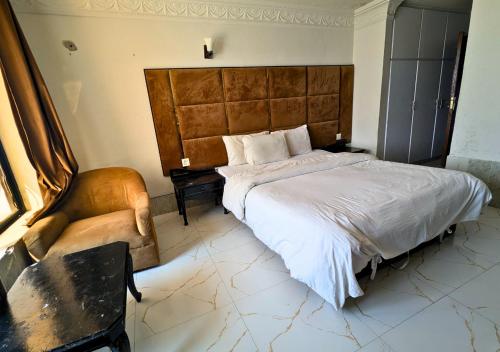 a bedroom with a large bed and a chair at Grand Heights Hotel in Murree