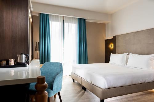 a hotel room with a bed and a desk and a bed at Elite Hotel & Spa in Mestre