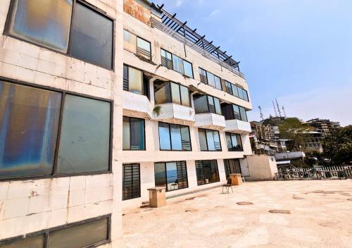 a building with windows and chairs in front of it at Grand Heights Hotel in Murree