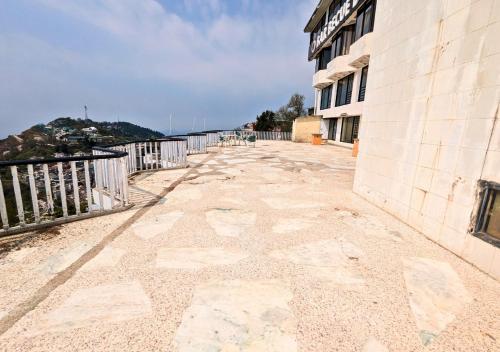 an empty sidewalk next to a building next to the water at Grand Heights Hotel in Murree