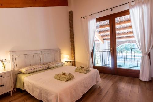 a bedroom with a bed and a large window at Agriturismo Monte Scala in Taglio di Po