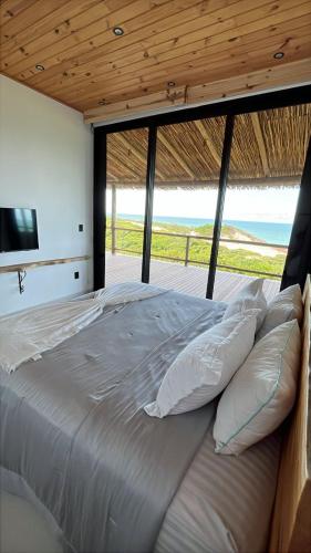 a bedroom with a bed with a view of the ocean at Casa Amar Pipa in Pipa