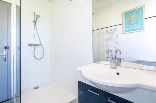 a white bathroom with a sink and a shower at Cozy Breizh -4 ch 8 pers- 1km plage in Penmarcʼh