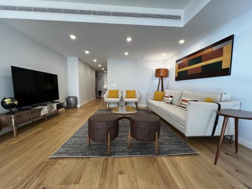 a living room with a couch and a tv at FLH Cascais Atrium Luxury Apartment with Sea View and Pool in Cascais