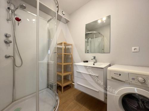 une salle de bain avec douche et lavabo et une machine à laver dans l'établissement APPARTEMENT EN RDC, 2 CHAMBRES, RES AVEC PISCINE, QUARTIER PORT DE SETE, à Sète
