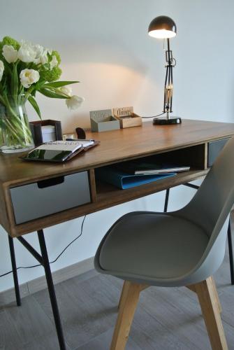 a desk with a chair and a vase of flowers at Lo-Gies in Lochristi