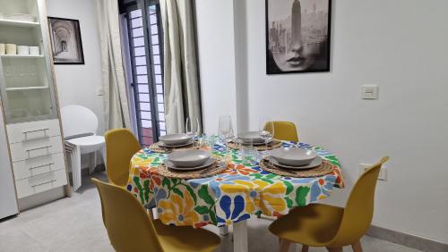 a dining room table with a colorful table cloth and chairs at Gran terraza Apartamento playa Garrucha in Garrucha