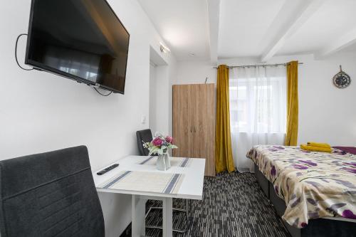 a room with a bed and a desk with a tv at Apartments Stars in Velika Gorica