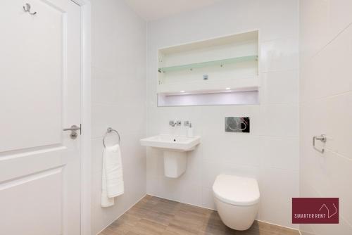a white bathroom with a toilet and a sink at Maidenhead - 4 bedroom house - garden and parking in Maidenhead