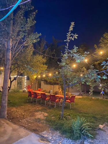 a table and chairs in a garden at night at Biafo Resort Skardu in Skardu