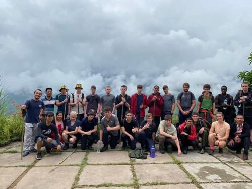 a group of people posing for a picture on a mountain at Long Chieu homestay in Hoàng Su Phì