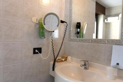 a bathroom with a mirror and a sink at Albergo Venezia in Passo Rolle