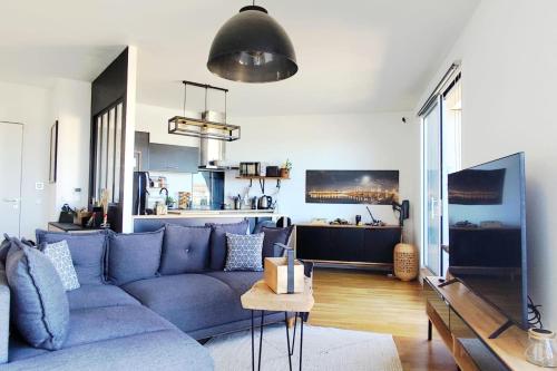 un salon avec un canapé bleu et une cuisine dans l'établissement Apartment 2 rooms with terrace in Bordeaux, à Bordeaux