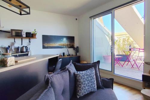un salon avec un canapé et une grande fenêtre dans l'établissement Apartment 2 rooms with terrace in Bordeaux, à Bordeaux