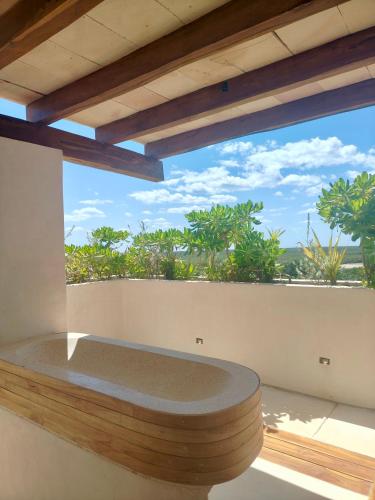 a room with a large window with a view of the ocean at Azucar Hotel Tulum in Tulum