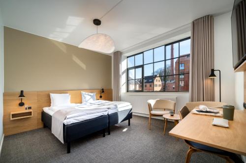 una camera d'albergo con un letto e una scrivania di Radisson Hotel Papirfabrikken Silkeborg a Silkeborg