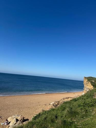 a sandy beach with the ocean in the background at Static Caravan on the Jurassic Coast at Freshwater Beach Holiday Park in Burton Bradstock