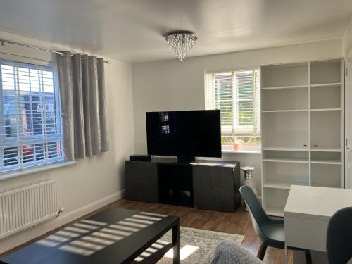 a living room with a flat screen tv and a table at Sheffield 3-Bed Warm Comfy home in Orgreave