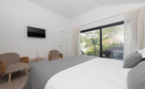 a bedroom with a bed and a large window at Estoril Village Guest House in Estoril
