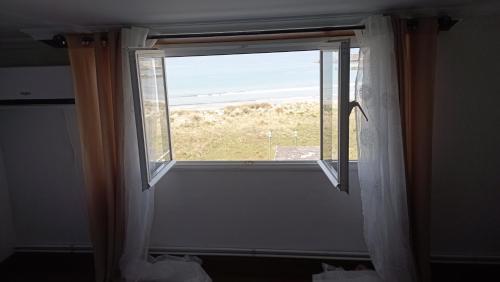 a window in a room with a view of the ocean at Apartamento Planeta 2º centro in O Porto de Espasante