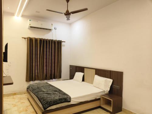 a bedroom with a bed and a ceiling fan at Sri Rameshwar Paradise in Rāmnagar