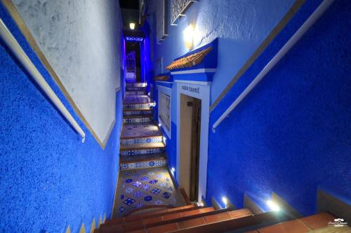 a stairway with blue walls and blue stairs at Casa Sanae in Chefchaouene