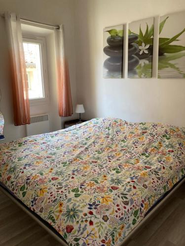 - une chambre avec un lit doté d'une couverture fleurie dans l'établissement Bright and airy apartment for 2 guests near Marché Provencal, à Antibes
