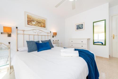a bedroom with a large white bed with blue pillows at Wintowinrentals Urban Rincón - Cozy & Central next to Beach in Rincón de la Victoria