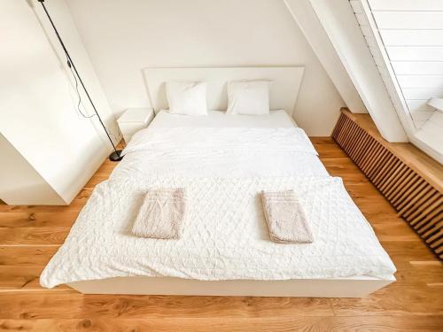 a white bed with two pillows on it in a room at VK - H - Zürich Airport - Luxury - Homestay - Haldenstrasse - Kloten in Kloten