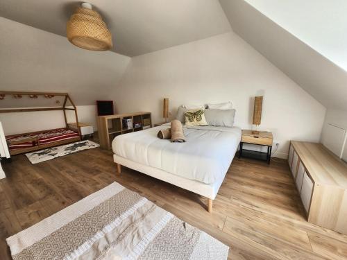 a bedroom with a large white bed and wooden floors at Villa Marine, Jacuzzi, 25' Disneyland in La Celle-sur-Morin