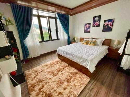 a bedroom with a bed and a large window at Bean Villa Tam Đảo in Tam Ðảo