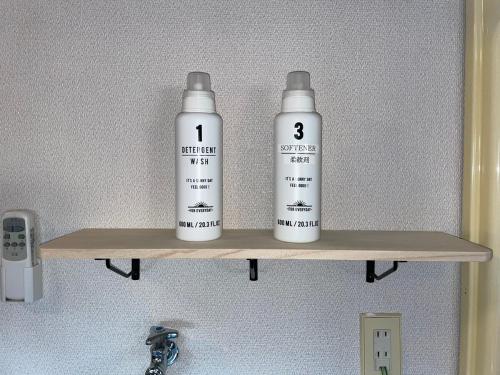 two bottles sitting on a shelf above a sink at BBQ on the terrace, 5-minute walk to the sea, private surf house in Shirako