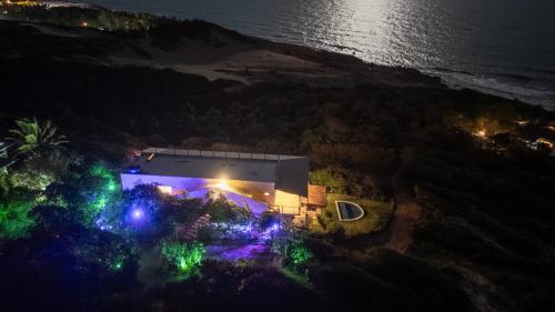 an aerial view of a house at night with lights at Casa Amar Pipa in Pipa