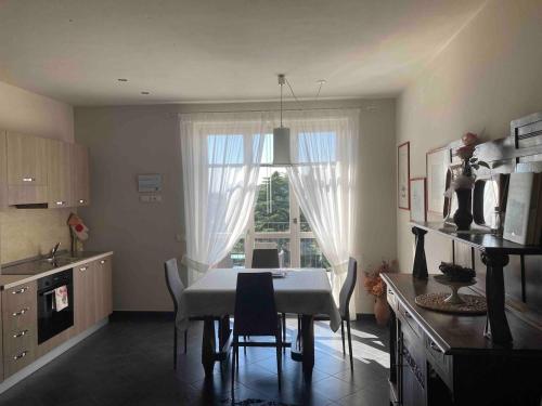a kitchen with a table and chairs and a window at La casa dei nonni in Monforte dʼAlba