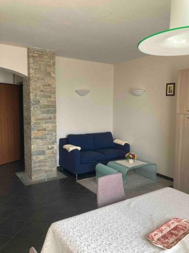a living room with a blue couch and a table at La casa dei nonni in Monforte dʼAlba