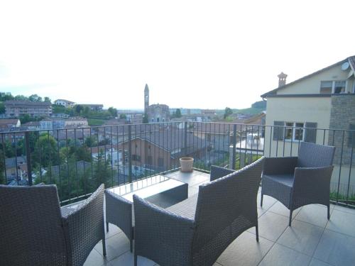 a balcony with chairs and a table on a balcony at La casa dei nonni in Monforte dʼAlba