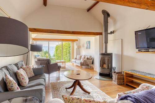 a living room with a couch and a fireplace at Spacious farmhouse with stunning valley views in Woodchester