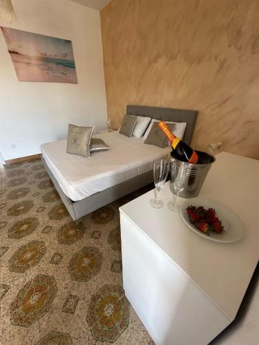a room with a bed and a table with a bottle of wine at Greta Apartment Tropea in Tropea