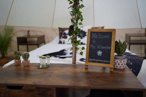 a sign on a wooden table with potted plants at Grotto Getaway in Miller Lake