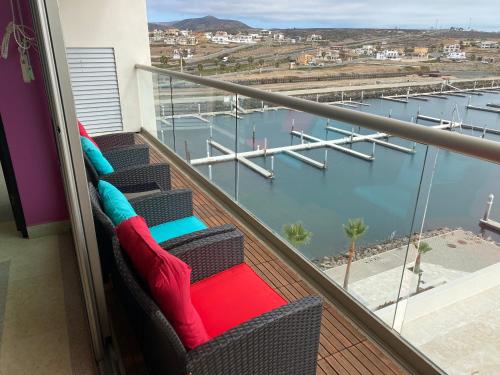 a balcony with chairs and a view of a marina at Baja Luxury With Spectacular Ocean Views Ensenada in Marisol