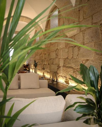 a living room with two couches and a stone wall at MS Collection Arouca - Mosteiro de Arouca in Arouca